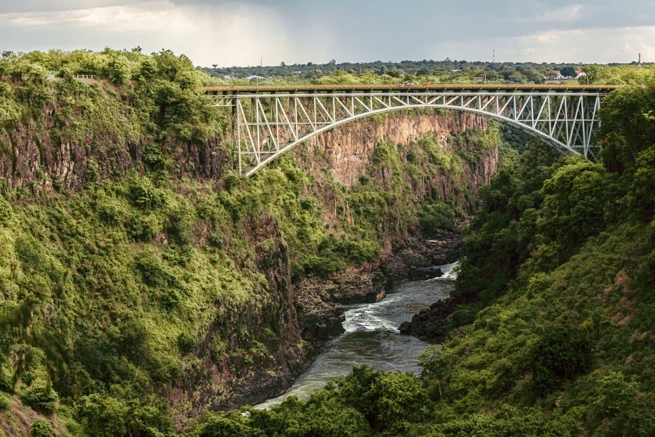 Victoria Falls Bridge gracefully arcs over the lush Batoka Gorge in Zimbabwe, showcasing stunning natural beauty.